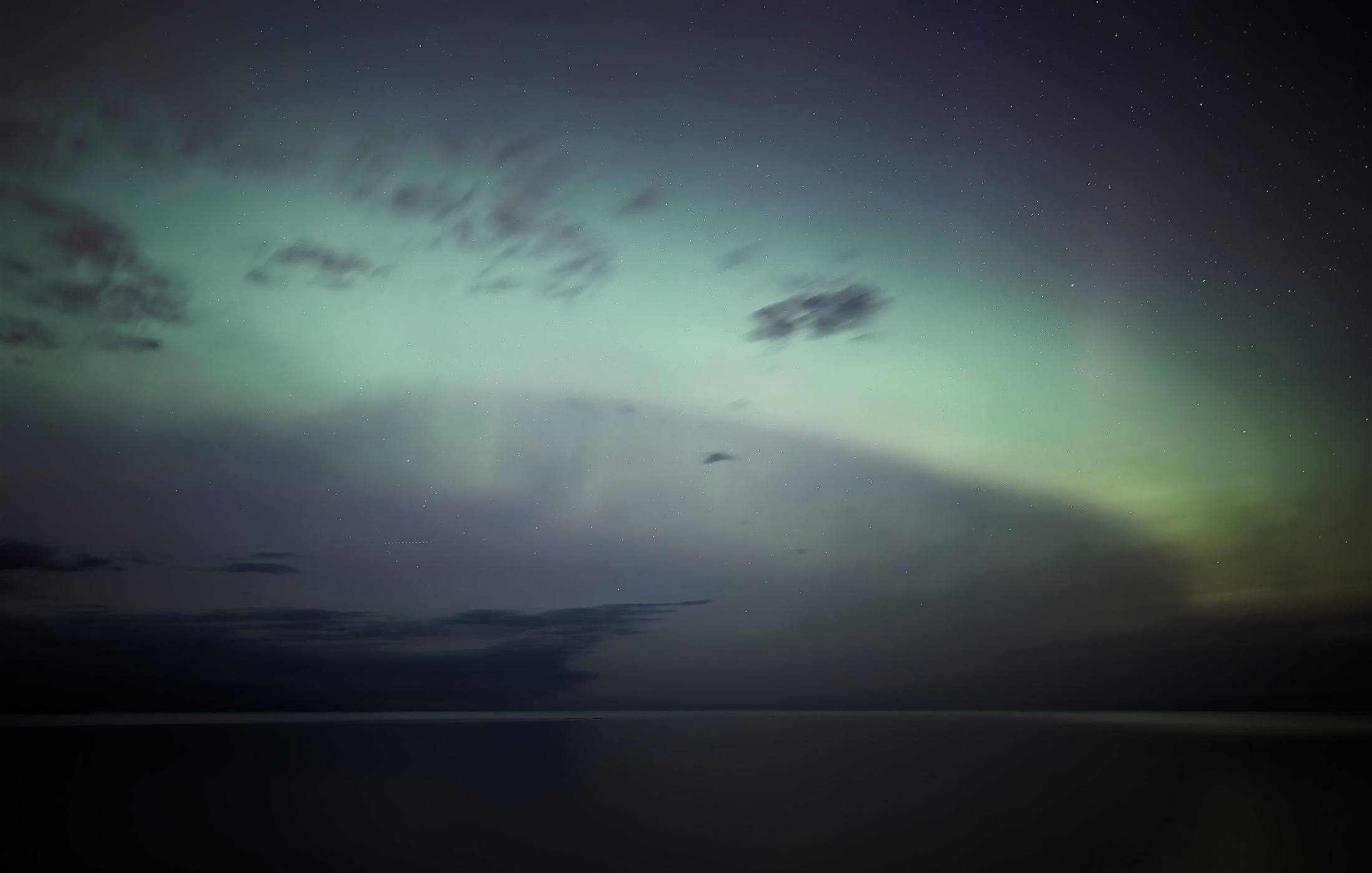 The aurora over a dark sky and still water