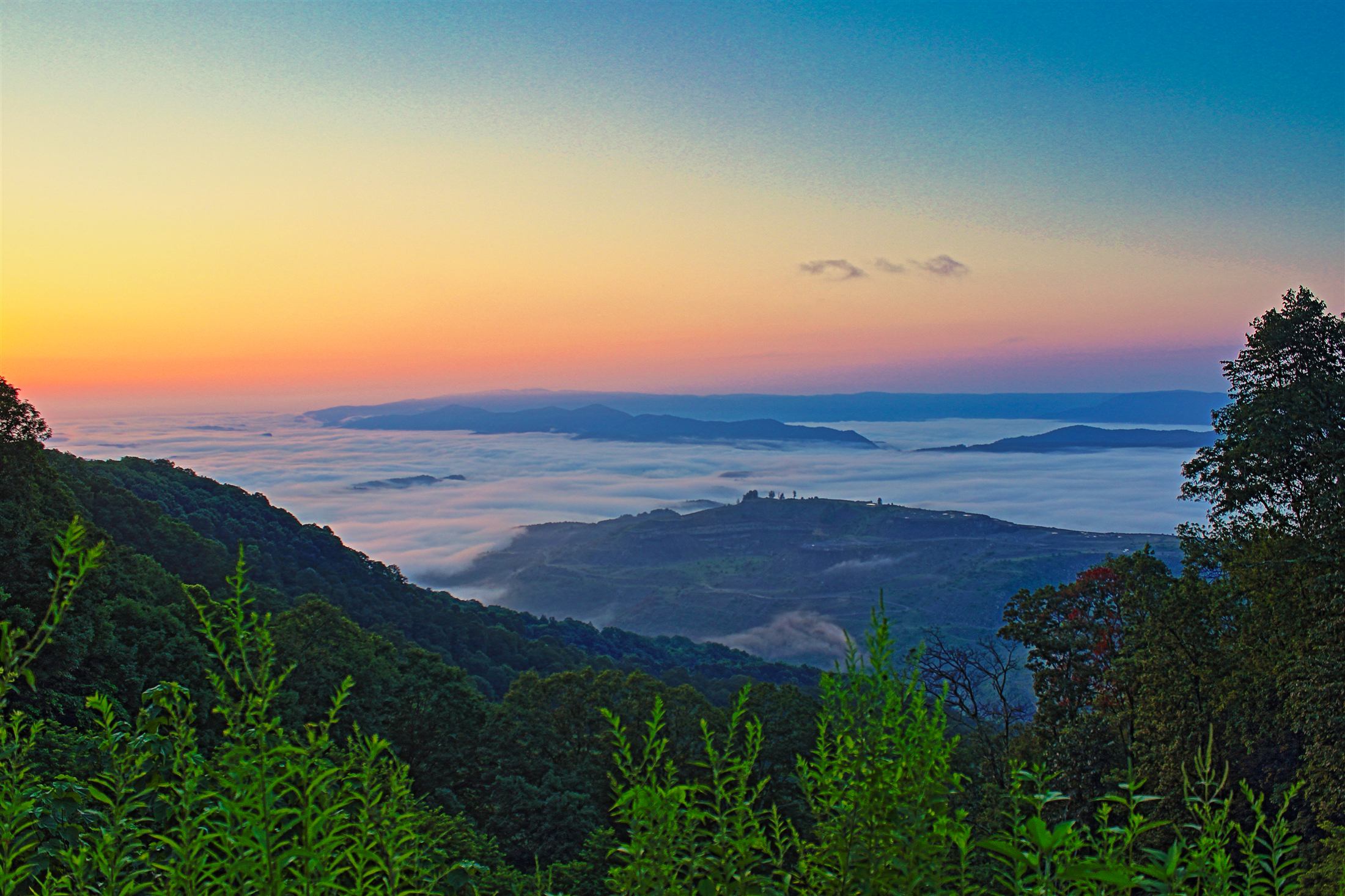 Sunrise over a fog-filled mountain valley